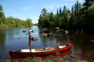 A canoe and fisherman on the upper St. Croix River A canoe and fisherman on the upper St. Croix River