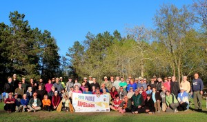 Paddles on the 2013 trip smile in the sun their last night on the Namekagon River.