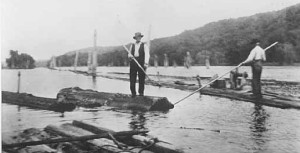 John Brennan, Boom Superintendent, with pike pole in hand, rides the last log to, and through the Gap of the St. Croix Boomsite at Stillwater. Famed photographer John Runk captured this moment in history on June 12, 1914 at precisely 2:30 that afternoon, one hundred years ago.